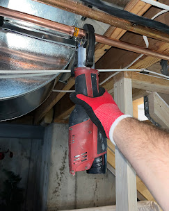 Emergency pipe repair in crawl space — copper line being cut and replaced