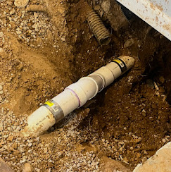 Excavated sewer line replacement — new PVC pipe in trench